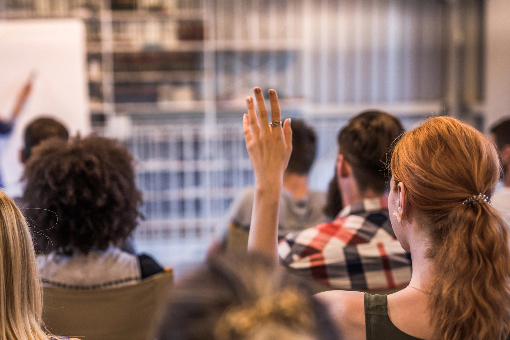 Eine Frau meldet sich während eines Seminars.